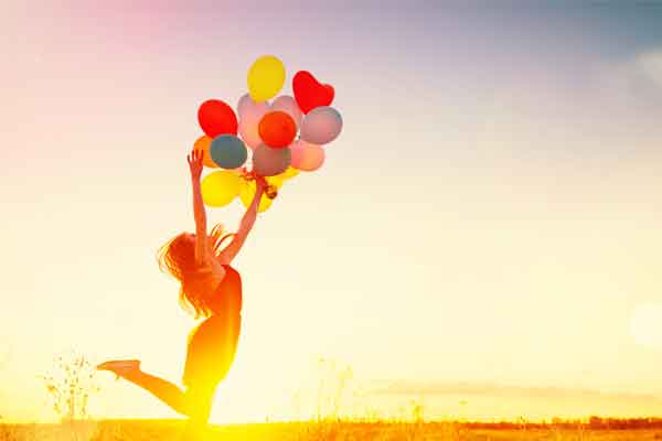 Woman jumping with balloons