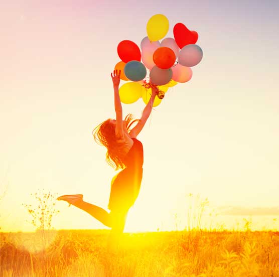 Woman jumping with balloons