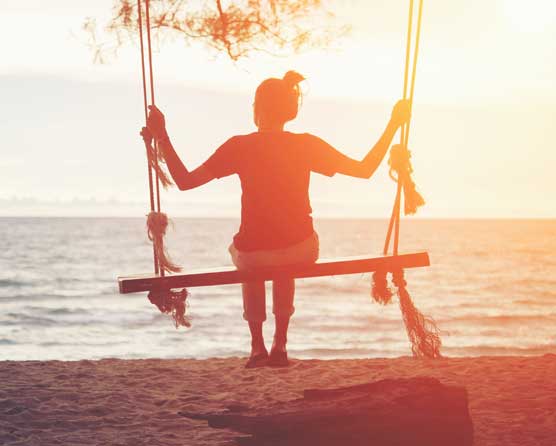 Woman on a swing looking out to sea