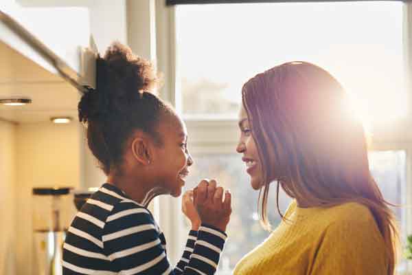 Mother and daughter smiling at each other.