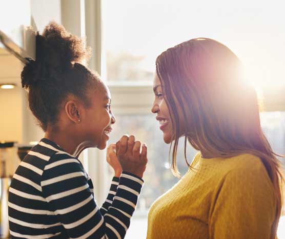 Mother and daughter smiling at each other.