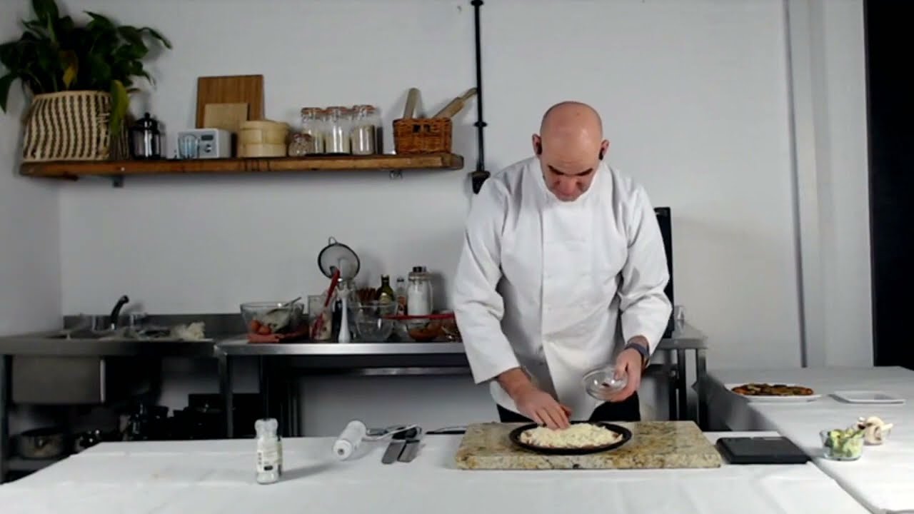 Chef Neil adding toppings to Cauliflower Crust Pizza